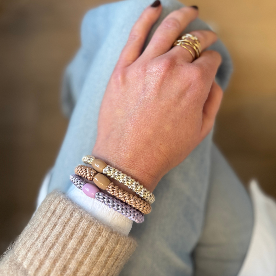 Am Handgelenk als Armbänder getragene Haargummis von Pizzicato in Flieder Zimt Taupe